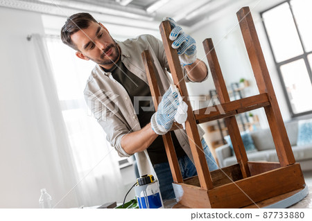 man cleaning old table surface with tissue man cleaning old table surface with tissue 87733880