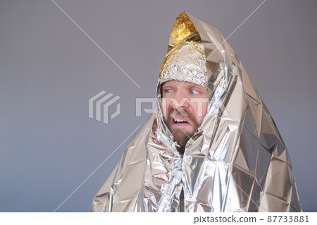 Lost hiker wrapped in an emergency survival blanket Lost hiker wrapped in an emergency survival blanket 87733881