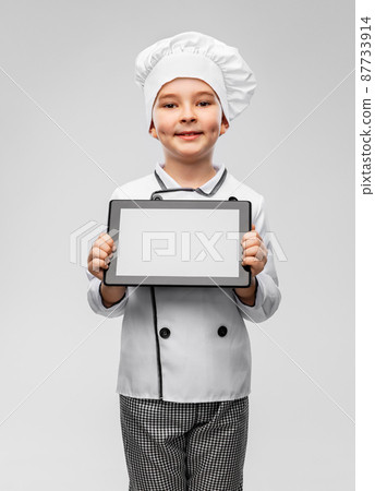 smiling little boy in chef's toque with tablet pc smiling little boy in chef's toque with tablet pc 87733914
