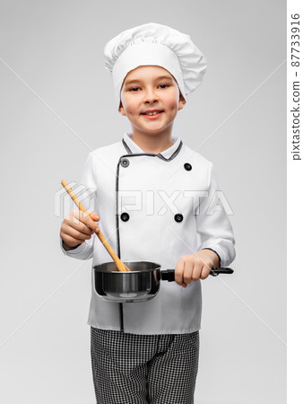boy in chef's toque with saucepan cooking food boy in chef's toque with saucepan cooking food 87733916