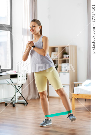 woman exercising with resistance band at home woman exercising with resistance band at home 87734101