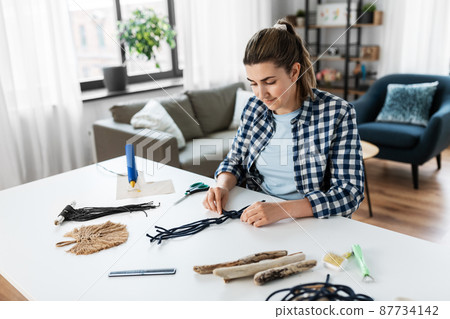woman making or knotting macrame on table at home woman making or knotting macrame on table at home 87734142