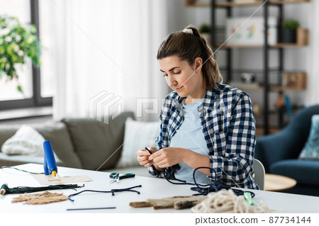 woman making or knotting macrame on table at home woman making or knotting macrame on table at home 87734144