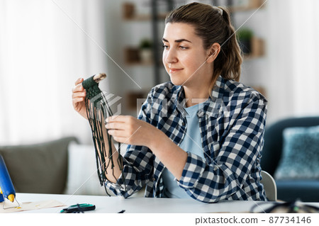 woman making or knotting macrame on table at home woman making or knotting macrame on table at home 87734146