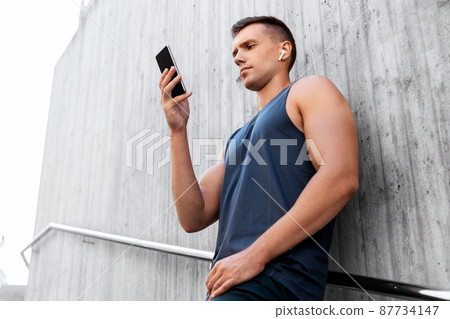 young athlete man with earphones and smartphone 87734147