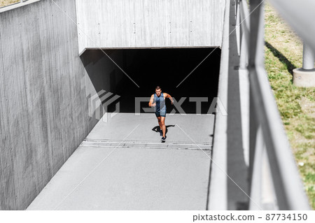 young man running out of tunnel 87734150