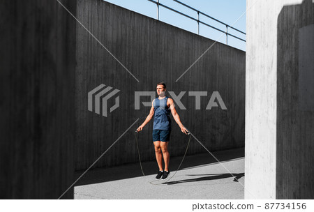 man exercising with jump-rope outdoors man exercising with jump-rope outdoors 87734156