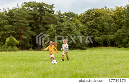 little children with ball playing soccer at park little children with ball playing soccer at park 87734173