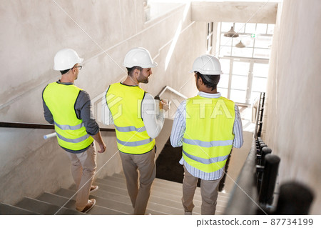architects in helmets walking downstairs at office 87734199