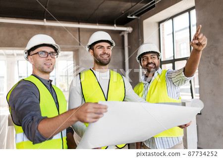 architects in helmets with blueprint at office architects in helmets with blueprint at office 87734252