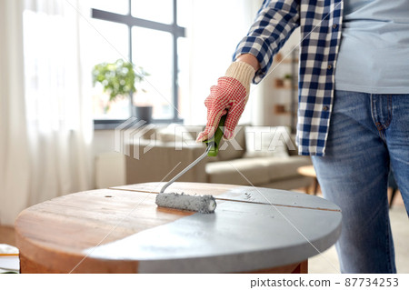 woman painting old wooden table in grey color woman painting old wooden table in grey color 87734253