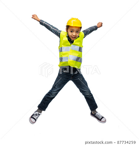 boy in safety vest and construction helmet jumping boy in safety vest and construction helmet jumping 87734259