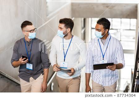 businessmen in masks with name tags going upstairs businessmen in masks with name tags going upstairs 87734304
