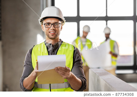 male architect in helmet with clipboard at office 87734308