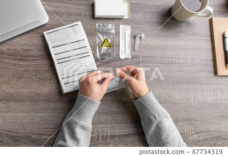 woman unpacking coronavirus test kit at home woman unpacking coronavirus test kit at home 87734319