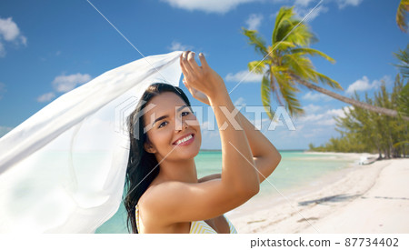 woman in bikini swimsuit with cover-up on beach 87734402