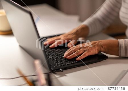 hands of senior woman typing on laptop at home 87734456