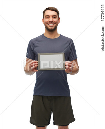 smiling man in sports clothes holdng tablet pc 87734463