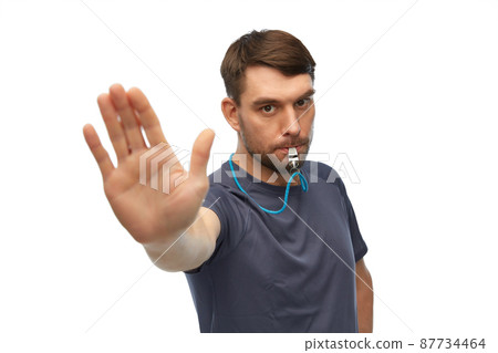 trainer or referee with whistle showing stop gesture trainer or referee with whistle showing stop gesture 87734464