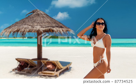 smiling young woman in bikini swimsuit on beach 87734525