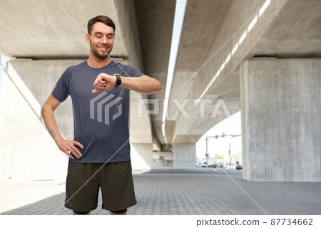 smiling man with smart watch or fitness tracker smiling man with smart watch or fitness tracker 87734662
