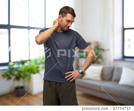 man with fitness tracker holding to aching neck 87734717