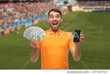happy laughing man holding smartphone and money happy laughing man holding smartphone and money 87734723