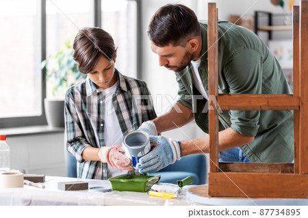 father and son pouring grey color paint into tray 87734895