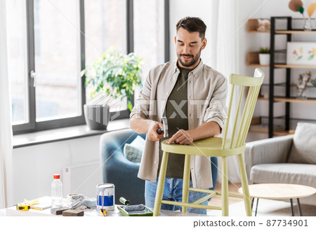 man with hammer repairing old wooden chair at home man with hammer repairing old wooden chair at home 87734901