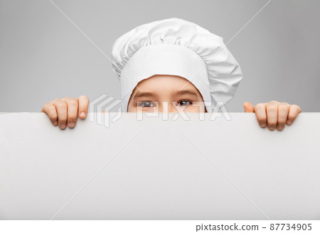 little boy in chef's toque behind white board little boy in chef's toque behind white board 87734905