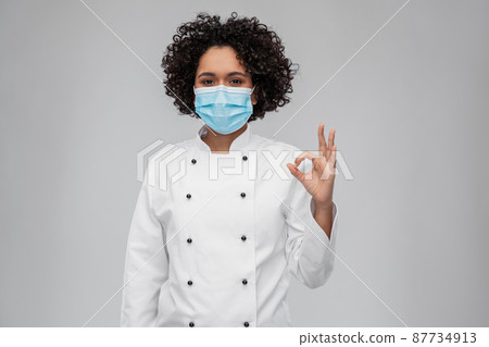 female chef in medical mask showing ok gesture 87734913