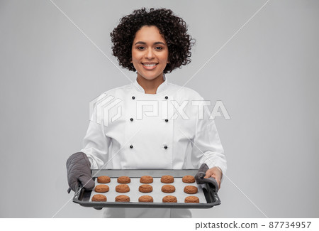 happy female chef with cookies on oven tray happy female chef with cookies on oven tray 87734957