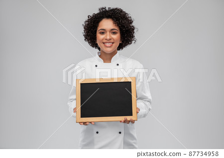 smiling female chef holding black chalkboard smiling female chef holding black chalkboard 87734958