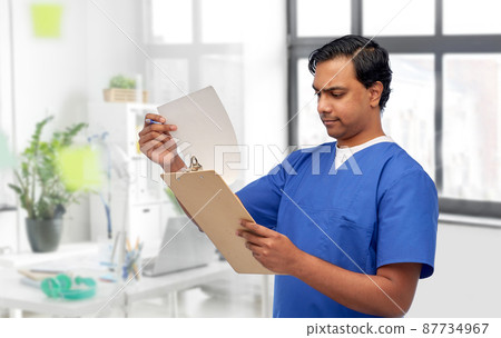 male doctor with papers on clipboard male doctor with papers on clipboard 87734967