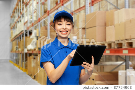 happy delivery woman with tablet pc at warehouse happy delivery woman with tablet pc at warehouse 87734968