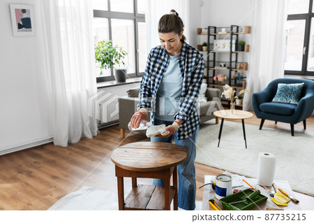 woman applying solvent to rag at home woman applying solvent to rag at home 87735215