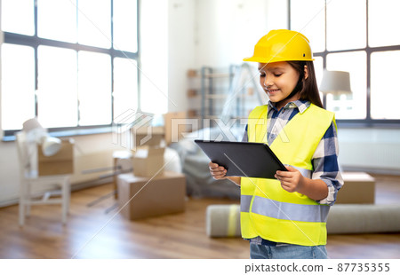 girl in helmet and safety vest with tablet pc girl in helmet and safety vest with tablet pc 87735355