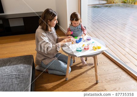 mother and daughter playing with modeling clay mother and daughter playing with modeling clay 87735358