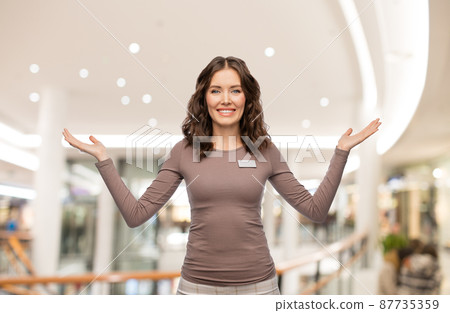 happy female shop assistant with name tag 87735359