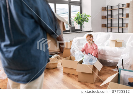 woman unpacking boxes and moving to new home woman unpacking boxes and moving to new home 87735512