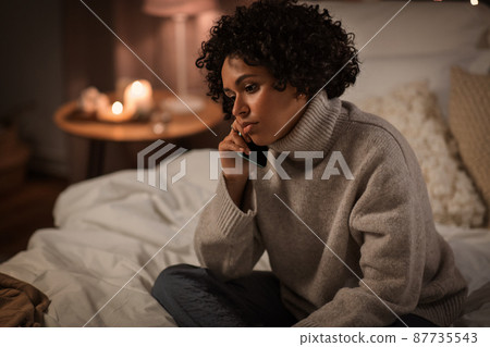 woman calling on smartphone in bed at home woman calling on smartphone in bed at home 87735543