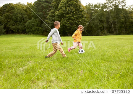 little children with ball playing soccer at park 87735550