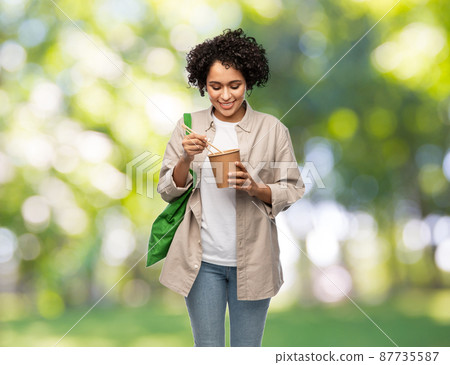 woman with green reusable shopping bag and wok 87735587