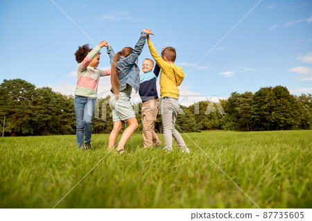 happy children playing round dance at park happy children playing round dance at park 87735605