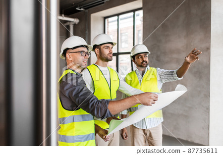 architects in helmets with blueprint at office architects in helmets with blueprint at office 87735611