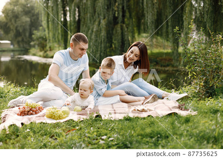 Happy family have a picnic in park near the lake 87735625