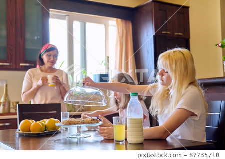 Children two sisters eating at home in the kitchen Children two sisters eating at home in the kitchen 87735710