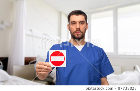 doctor or male nurse showing stop sign at hospital doctor or male nurse showing stop sign at hospital 87735825