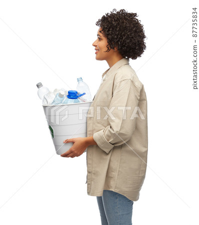 smiling young woman sorting plastic waste 87735834