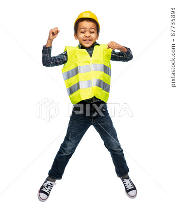 boy in safety vest and construction helmet jumping 87735893